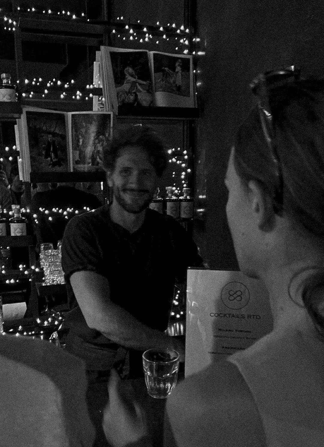 Mattia Di Bello sorride dietro il bancone di un bar