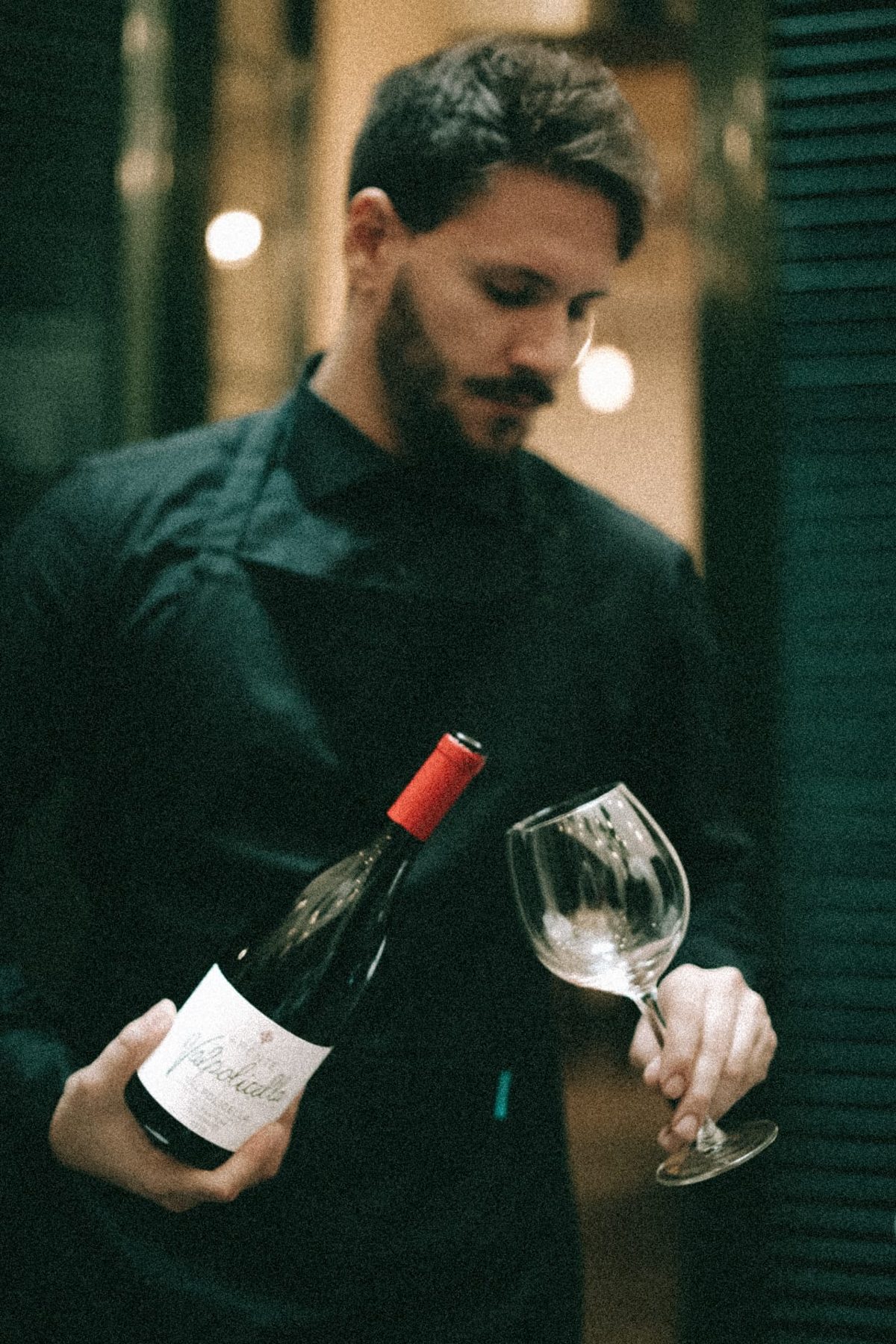 Mattia Di Bello, fondatore di Might Be Events, mentre serve un vino rosso